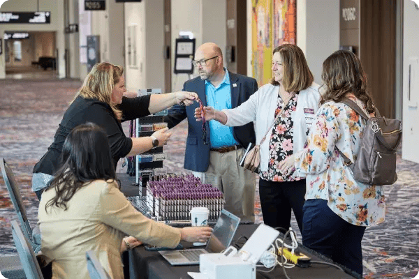 Attendees pick up their badges from event registration