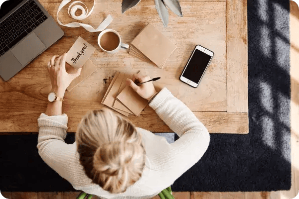 A fundraising volunteer writes handwritten thank you notes