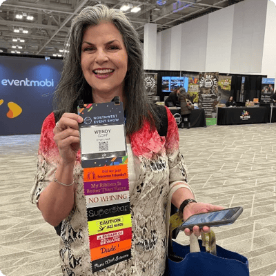 Convention attendee wears a badge with many badge ribbons