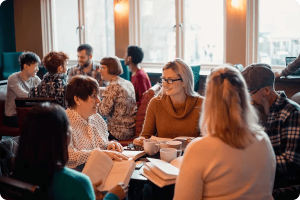 a group of employees discuss a professional development book