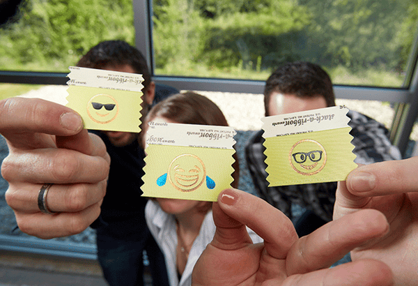 party attendees hold up emoji badge ribbons