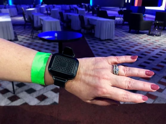 Event attendee wears social distancing wearable