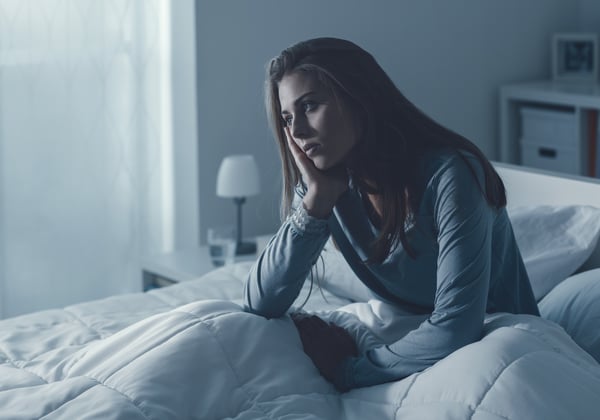 a stressed woman struggles to sleep