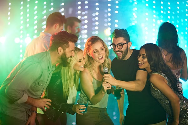 young adults sign karaoke at a music themed party