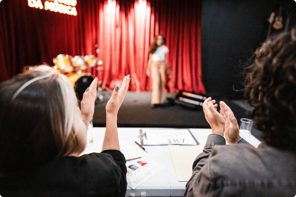 two women clap at a charity talent show