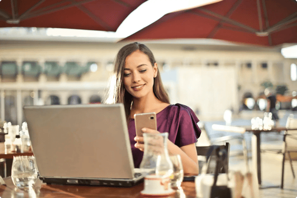 Event attendee checks her cell phone while using a computer