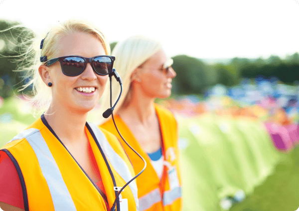 two event security guards patrol an outdoor festival