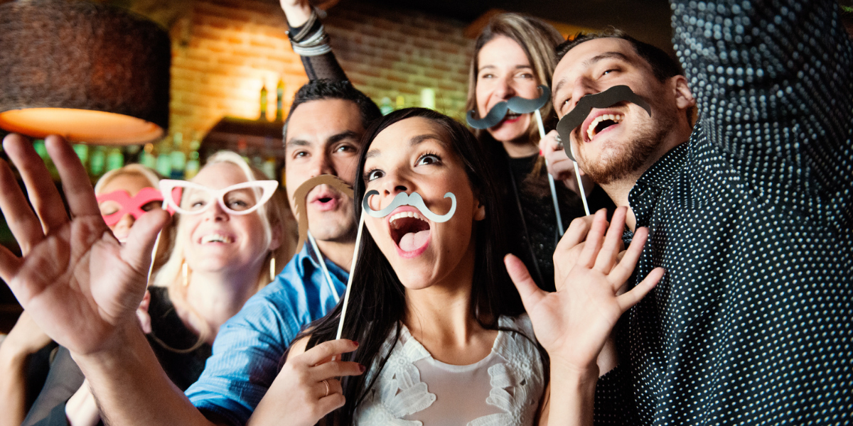 event attendees use photo booth props at a party 