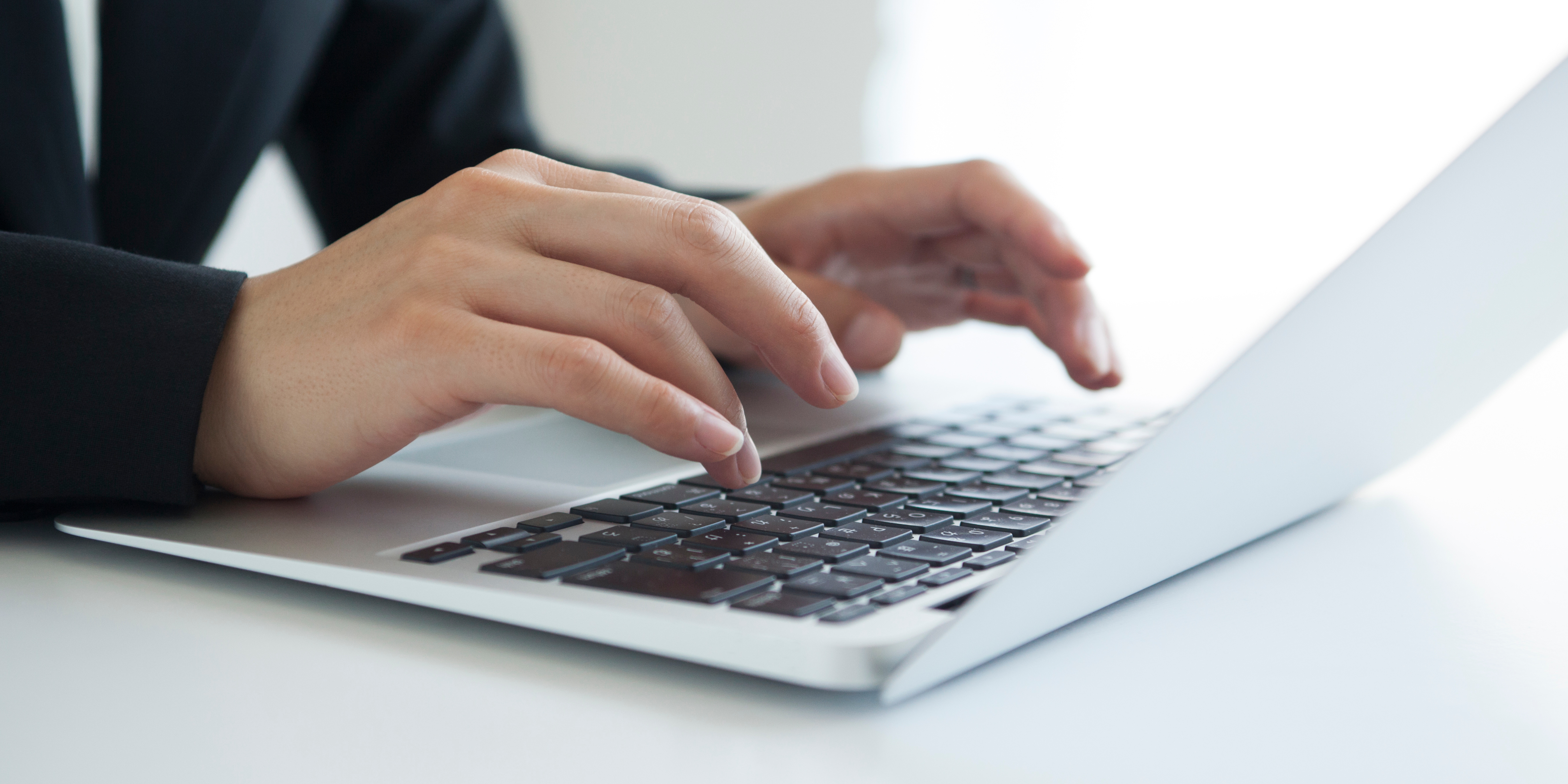 a person's hands typing on a keyboard