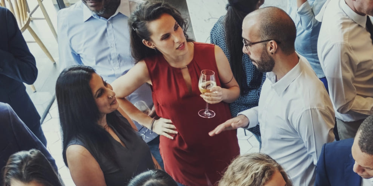 Two female attendees and one male attendee network at a non-profit event