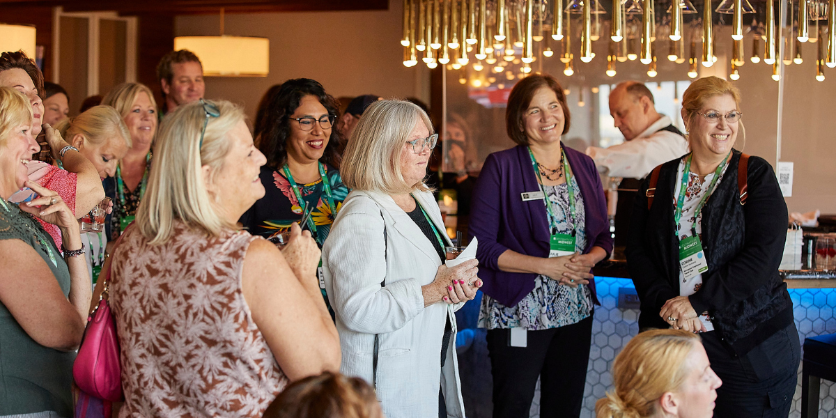 A room of smiling event attendees at an auction