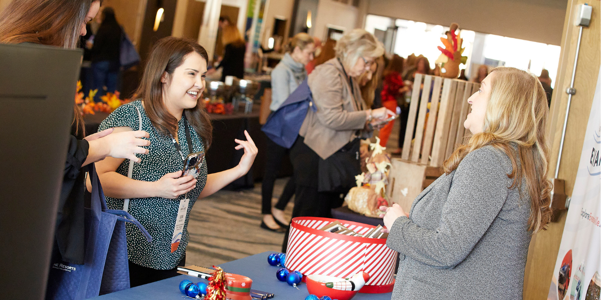 an event attendee visits with an exhibitor at a conference booth