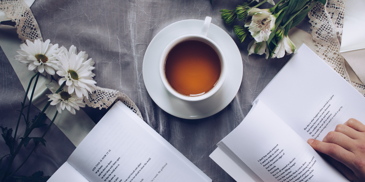 a cup of tea and a motivational book on a table