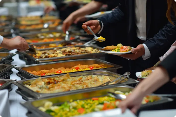 attendees take food from a buffet hosted by a local caterer