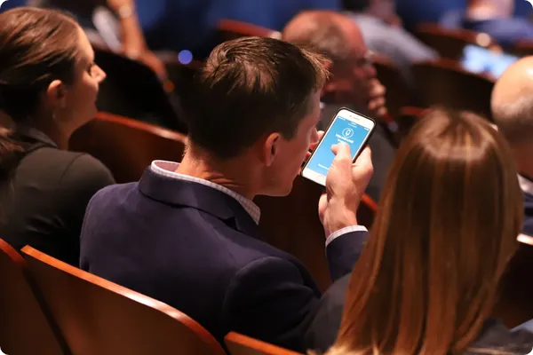 conference attendee uses the Crowd Mics phone app to ask a question