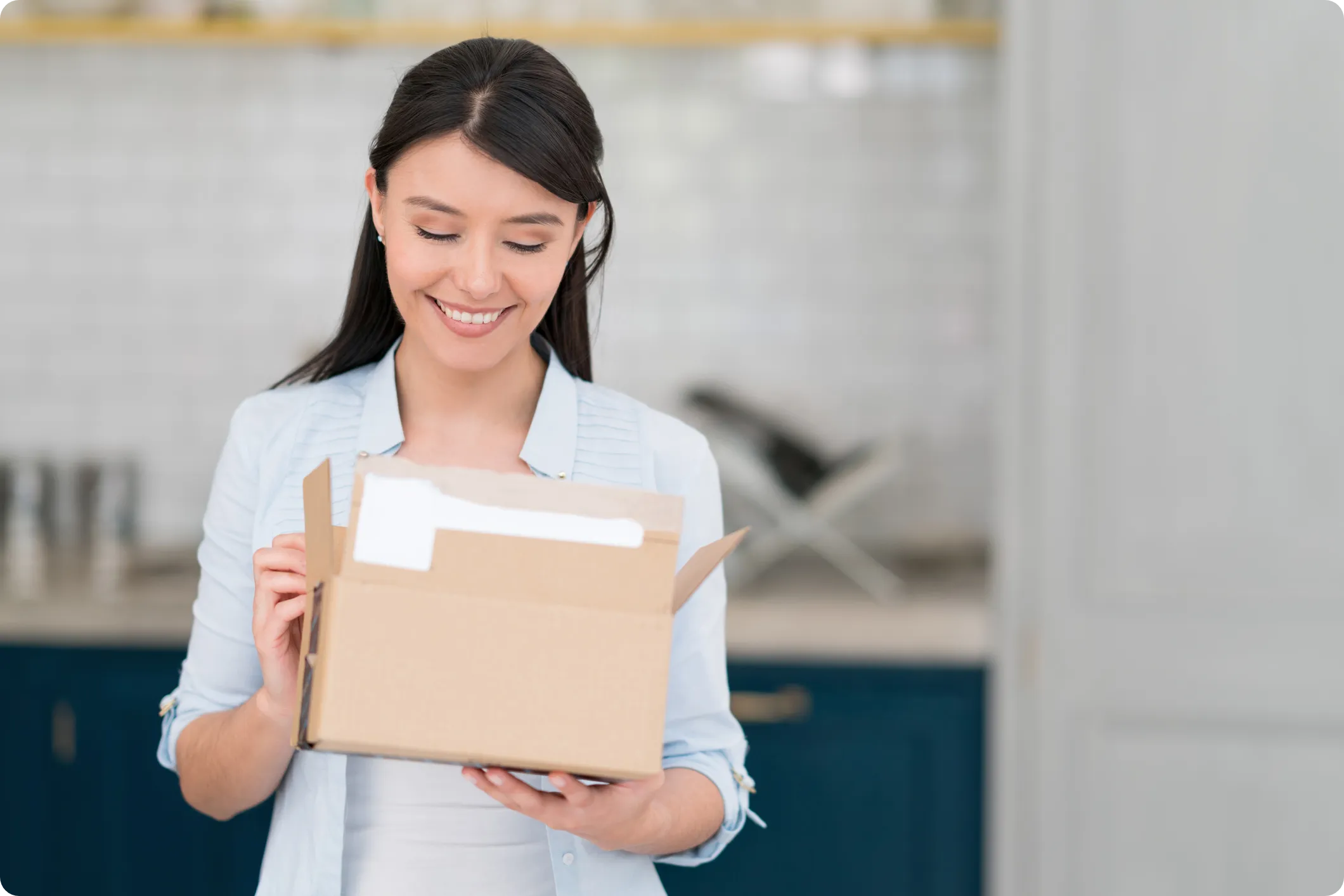 woman opens a box of direct mail marketing materials